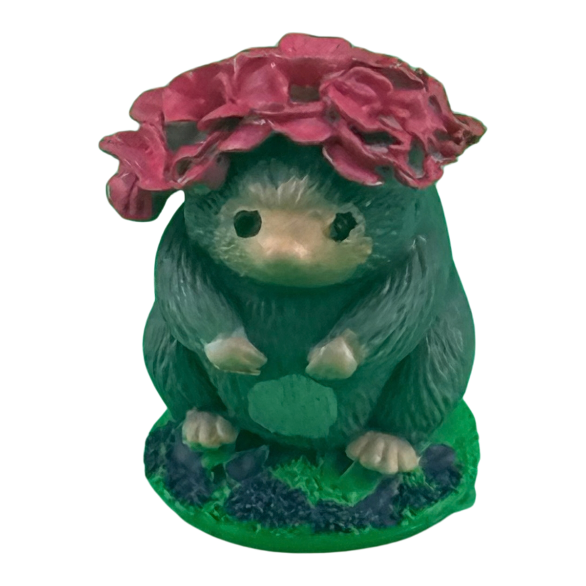 A hand-painted mole collectible from the Morning Glade, sitting on a mossy base in deep green, wearing a wide pink flower as a hat.
