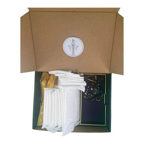 An open Fortune Coochi mailer box with the goddess seal inside the lid, packed with organic pads and liners in a dark green and gold star-printed tray.